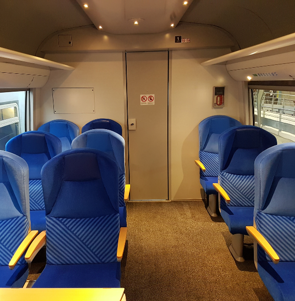 Intérieur moderne de train avec sièges bleus.